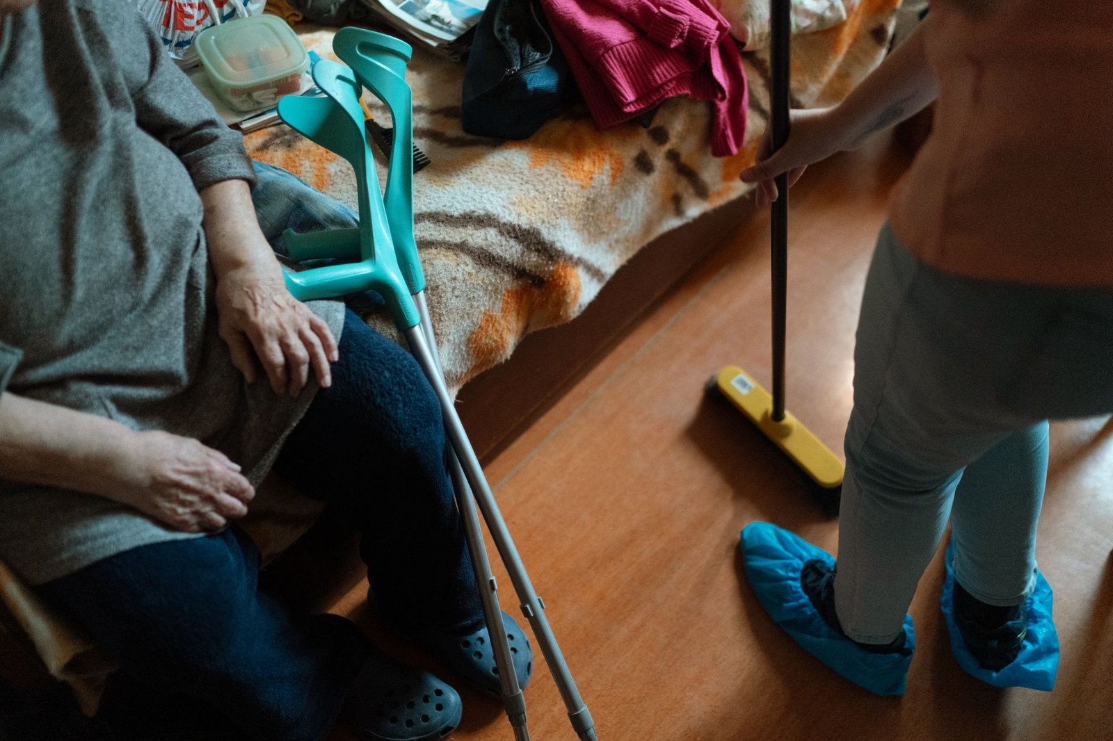 Live-in care agency support: caregiver helping an older woman at home with household tasks