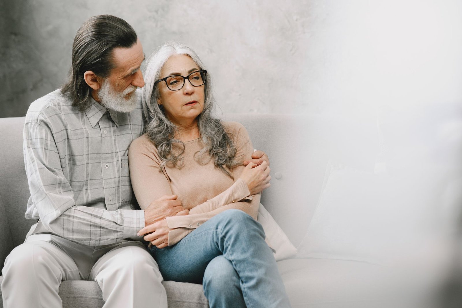 Private live-in carer support: older couple sharing a supportive conversation in a living room
