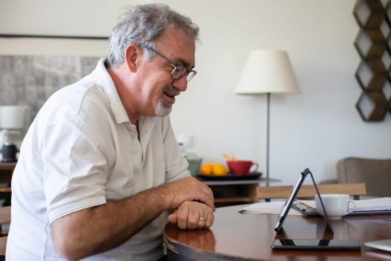 Stroke recovery care at home: older man using a tablet with support